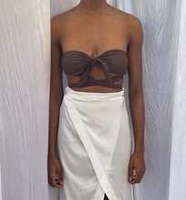 Load image into Gallery viewer, A women wearing the Browning Bikini, with the tie knot at the front of the bust and straps around the waist paired nicely with a high-waist skirt