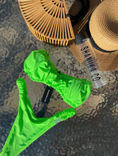 Load image into Gallery viewer, Green Barbie bikini on a waterfall backdrop styled with a handmade bamboo bag and straw hat all can be purchased on www.shaniika.com
